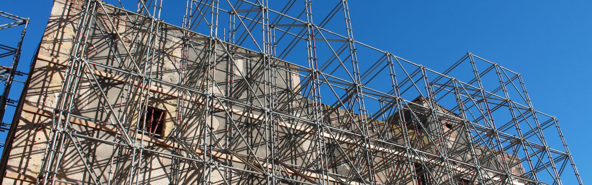 Obra de rehabilitación de edificios históricos con andamios en una fachada antigua